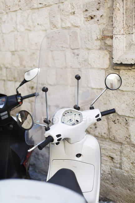 Italy, Ascoli Piceno, white Vespa motor scooter parked in front of ancient building — Stock Photo