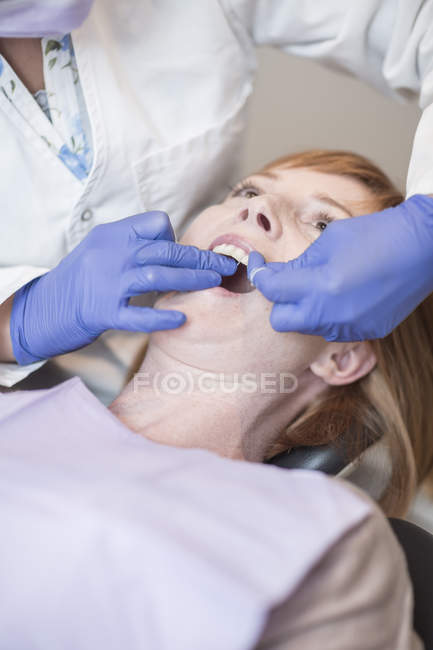 Dentista dentes fio dental de paciente do sexo feminino — Fotografia de Stock