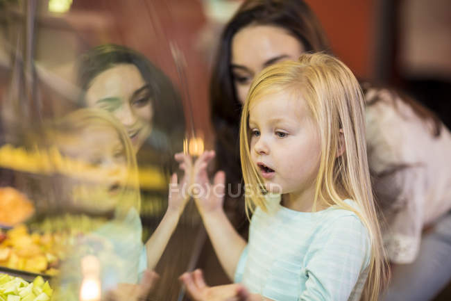 Mother and daughter looking at fruit salad in supermarket — Stock Photo