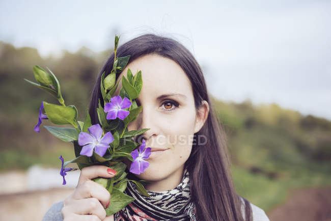 Mulher segurando monte de periwinkles no campo — Fotografia de Stock