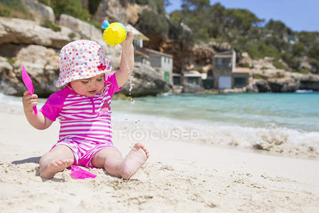 Bambina che gioca sulla spiaggia di sabbia — Foto stock
