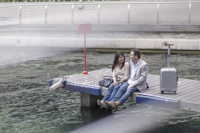 Man and woman sitting on a jetty — Stock Photo