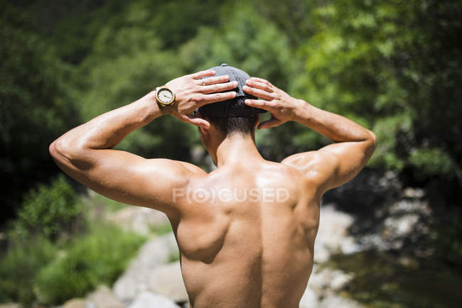 Parte posterior de un joven sin camisa que lleva reloj de pulsera — Stock Photo