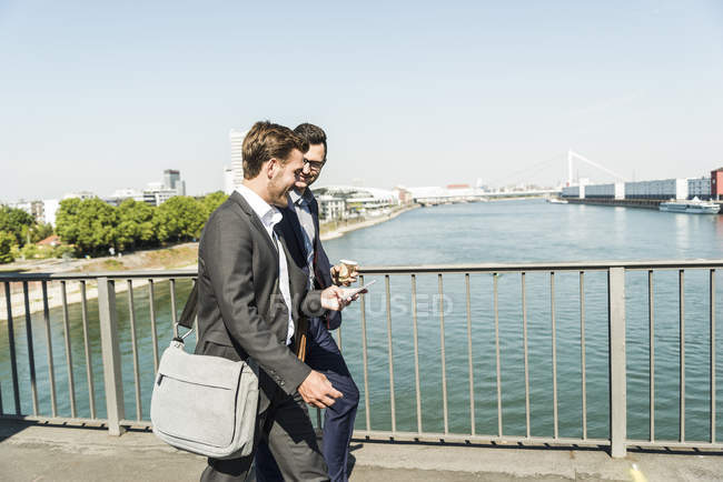Два молодих бізнес колег ходьба по річці, обговорюючи — стокове фото