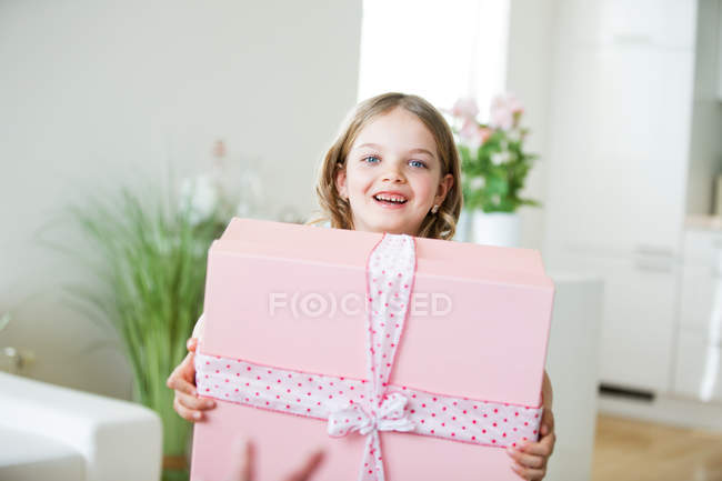 Menina carregando caixa de presente em casa — Fotografia de Stock