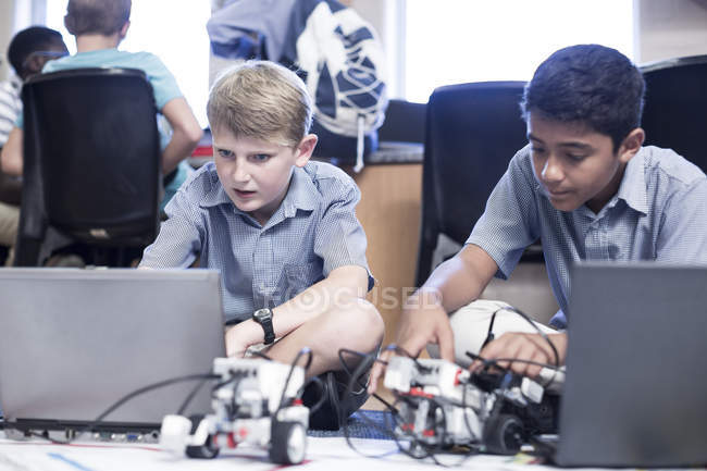 Schoolboys using laptops in robotics class — Stock Photo