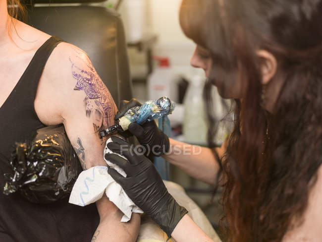 Vue rapprochée du tatoueur au travail en studio — Photo de stock