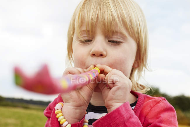 Porträt eines kleinen Mädchens mit Party-Blowout — Stockfoto