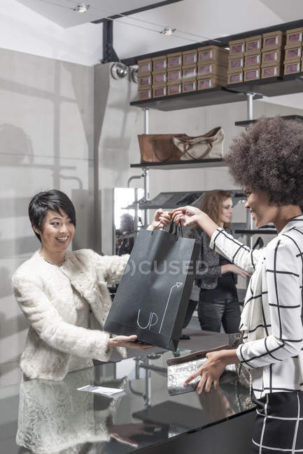 Femme souriante faisant du shopping dans une boutique de luxe — Photo de stock