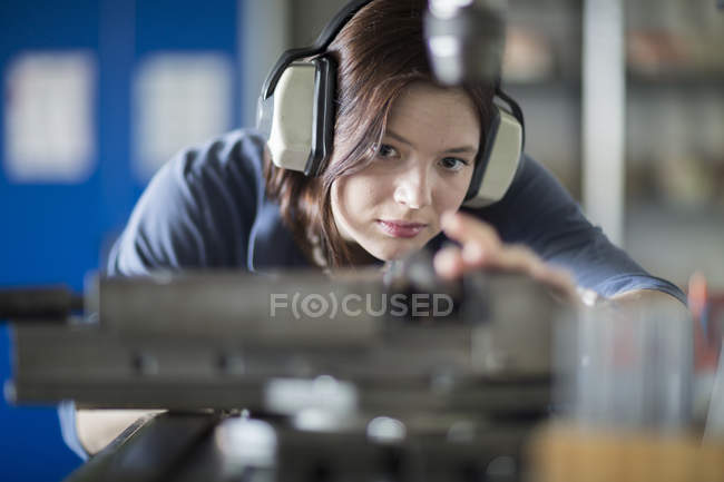 Giovane donna con auricolari che lavora a macchina — Foto stock
