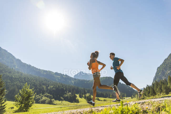 Австрия, Тироль, Таннинская долина, молодая пара бегает по пейзажу — стоковое фото