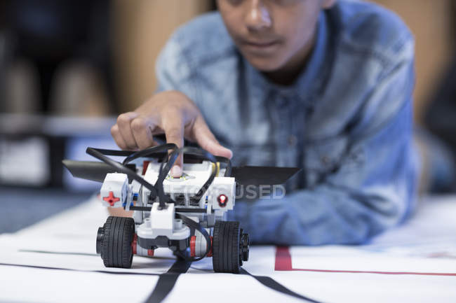 Schoolboy in robotics class testing vehicle on test track — Stock Photo
