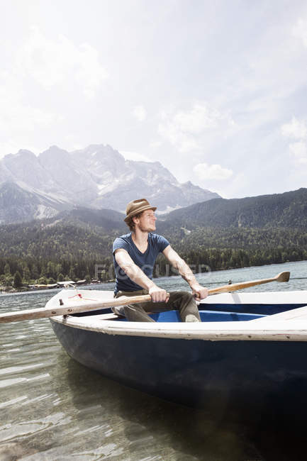 Germany, Bavaria, Eibsee, man in rowing boat on the lake — Stock Photo
