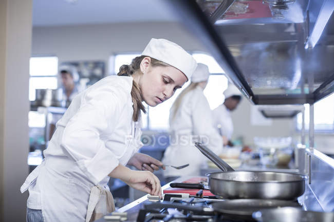 teenage girl in kitchen cooking dark lighting