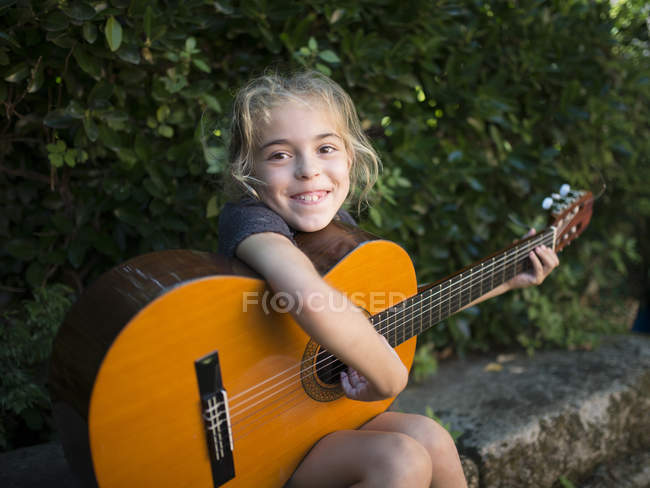 Дівчина грає на іспанській гітарі на відкритому повітрі — стокове фото