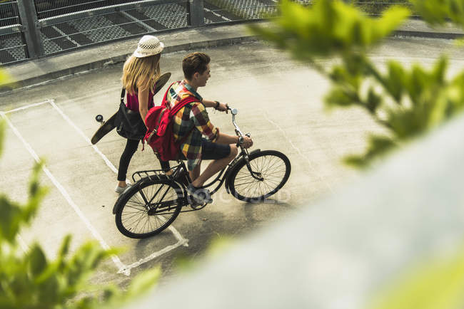 Jovem casal com bicicleta e skate — Fotografia de Stock