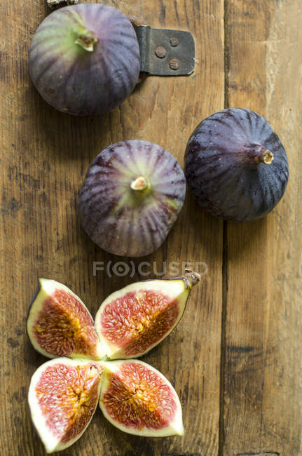 Closeup view of whole and cut figs on wood — Stock Photo