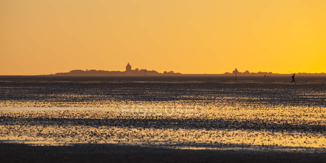 Germania, Bassa Sassonia, tramonto sul mare di Wadden con isola Neuwerk sullo sfondo — Foto stock
