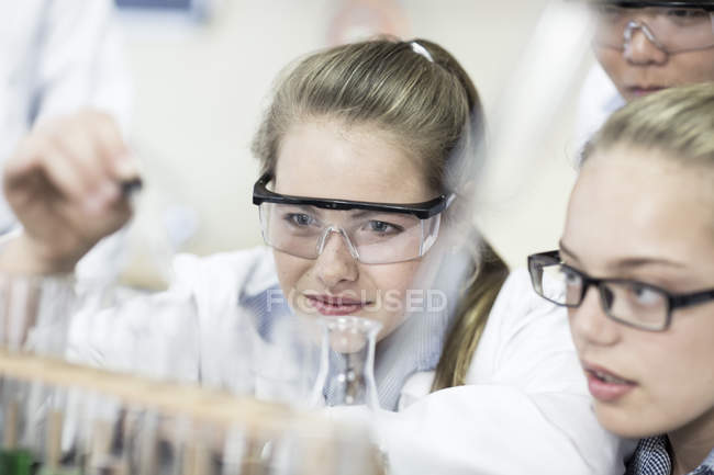 Schüler im Chemieunterricht pipettieren Flüssigkeit ins Reagenzglas — Stockfoto