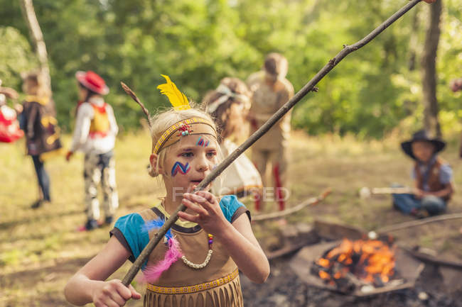 Germany, Saxony, Indians and cowboy party, Children rasting marshmallows on sticks — Stock Photo