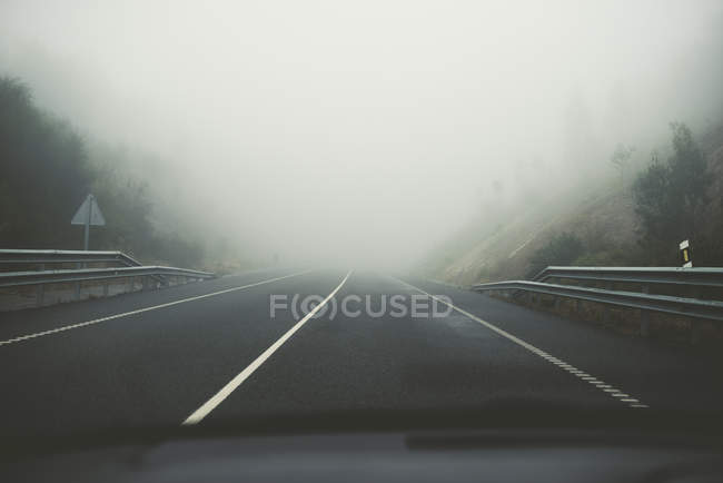 Spagna, vista dall'auto alla strada vuota con tempo nebbioso — Foto stock