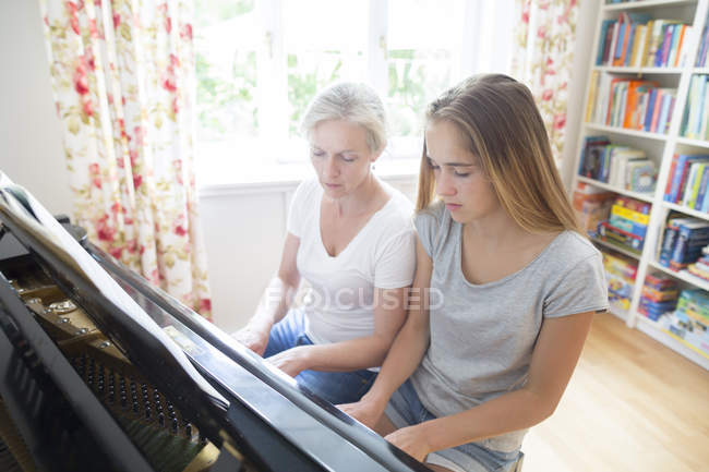 Мати і дочка, грати на фортепіано разом — стокове фото