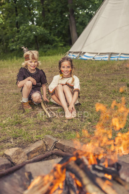 Germany, Saxony, Indians and cowboy party, Children sitting at bonfire — Stock Photo