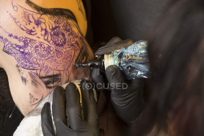 Vue rapprochée du tatoueur au travail en studio — Photo de stock