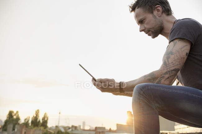 Deutschland, berlin, reifer mann auf dachterrasse mit digitalem tablet — Stockfoto