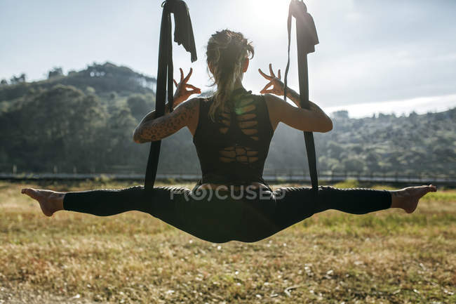 España, Villaviciosa, mujer practicando yoga aéreo al aire libre - foto de stock