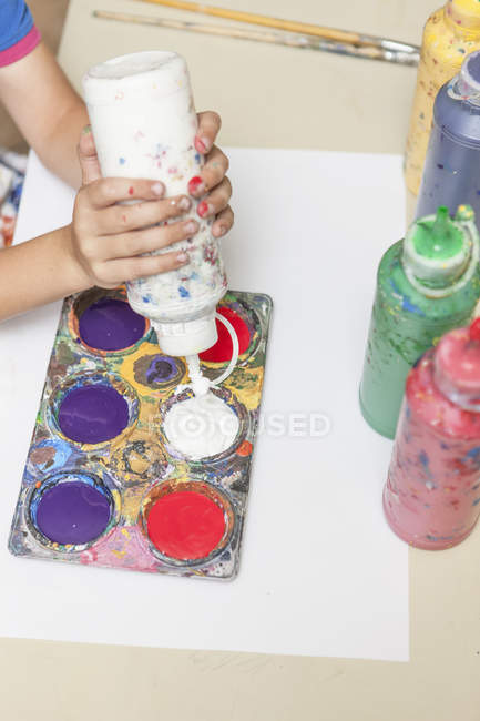 Junge presst im Kunstunterricht Farbflasche von Hand — Stockfoto