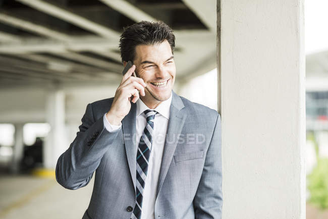 Portrait d'un homme d'affaires souriant téléphonant avec smartphone — Photo de stock