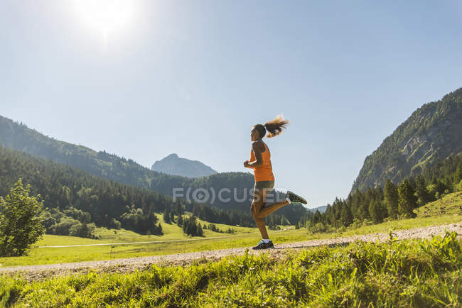 Austria, Tirol, Valle de Tannheim, joven trotando en el paisaje alpino - foto de stock