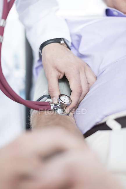 Doctor measuring blood pressure — Stock Photo