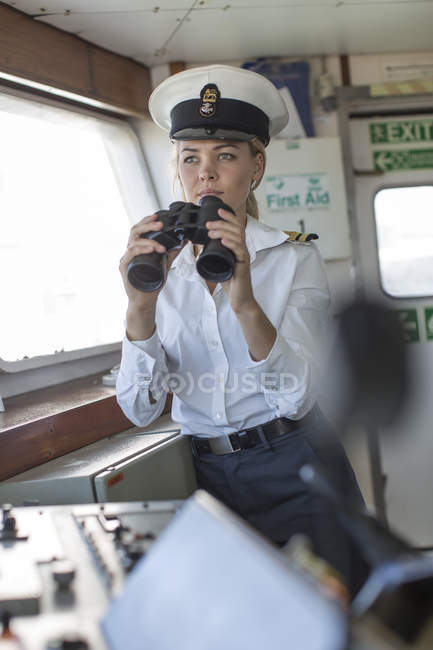 Deck officer on ship holding binoculars — Stock Photo