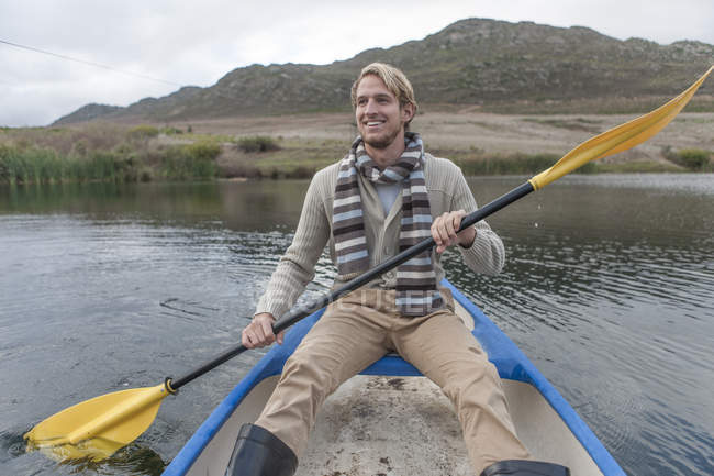 Portrait de jeune homme heureux pagayant sur un lac — Photo de stock