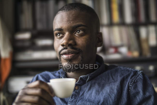 Homme assis avec une tasse de café — Photo de stock