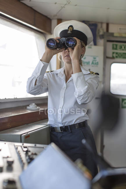 Ufficiale di coperta sulla nave che guarda attraverso il binocolo — Foto stock
