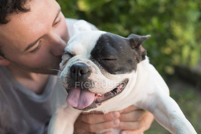 Man kissing his French bulldog — Stock Photo