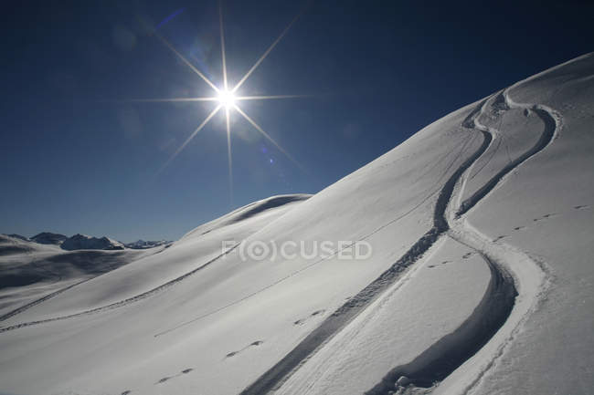 Austria, Kitzbuehel, neve con piste da sci contro il sole — Foto stock