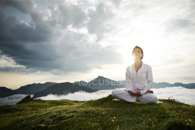 Austria.Kranzhorn, Mid adult woman practising yoga on mountain top — Stock Photo