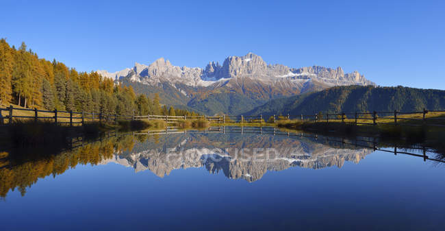 Italy, Bozen Province, Dolomites, Rosengarten group reflected in a small lake — Stock Photo