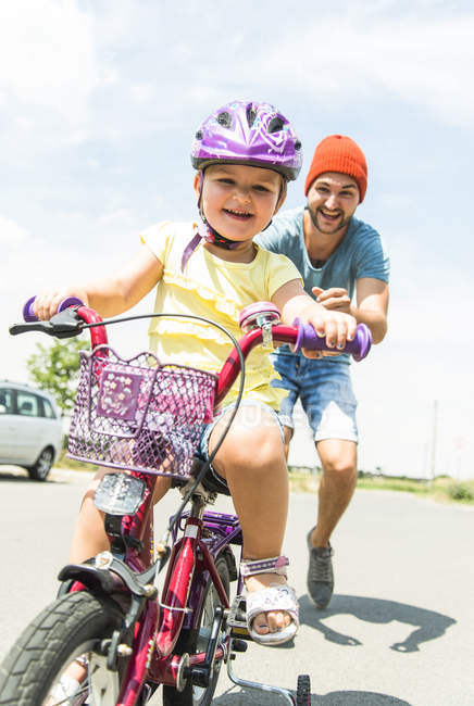 Father accompanying daughter on bike — Stock Photo