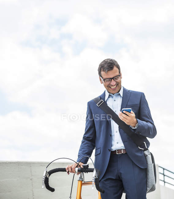 Geschäftsmann mit Fahrrad per Smartphone — Stockfoto