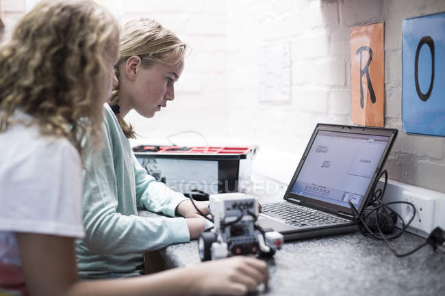 Two schoolgirls with laptop learning in robotics class — Stock Photo