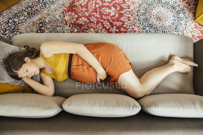 Pregnant woman taking a nap on her couch at home — Stock Photo