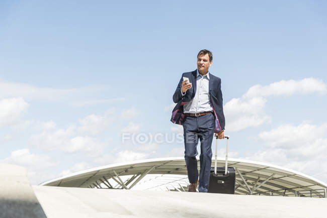 Geschäftsmann auf Geschäftsreise kommt mit Einkaufswagen — Stockfoto