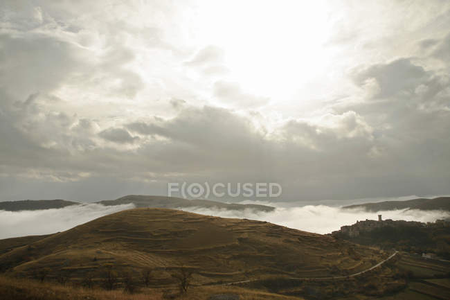 Village and rolling landscape in fog, Abruzzo, Italy — Stock Photo