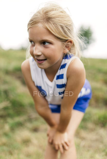 Retrato de menina loira dobrando e olhando para longe — Fotografia de Stock