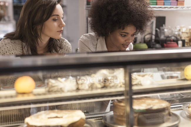 Junge Frauen wählen Kuchen von der Kuchentheke im Café — Stockfoto